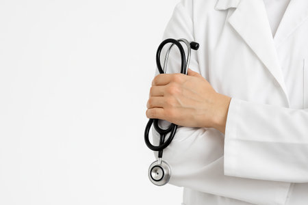 Professional male doctor holding stethoscope on white background. concept of healthcare professional, medical expertise, doctor readiness, modern medicine, copy space, white background.の写真素材
