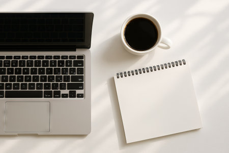Laptop and coffee with calendar on white table for simple planning and organization concept.