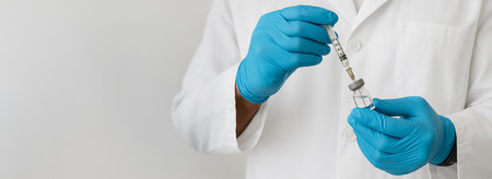 Medical procedure featuring injection with doctor in protective gloves in healthcare setting. sterile environment, health service, medical safety, Wide banner, copy space, white background.の写真素材