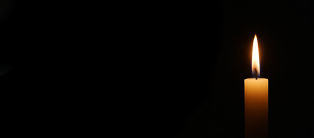 Candlelight ritual moment in darkness emphasizing simplicity and tranquility. concept of meditation, peaceful ambiance, spiritual reflection, copy space.の写真素材