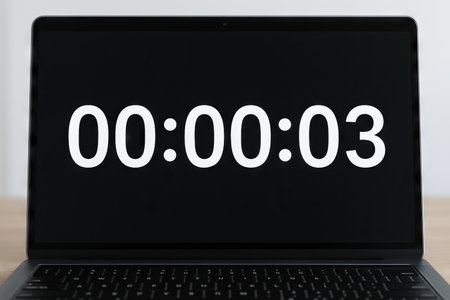 Digital countdown timer displayed on laptop screen with three-second countdown concept of time...