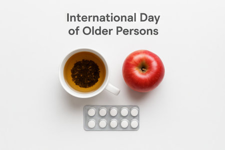 Cup of tea, red apple, and tablets celebrating international day of older persons. concept of health, nutrition, daily routine, elderly wellbeing, senior care, healthcare.の写真素材