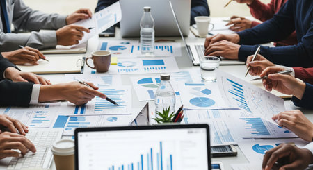 Business professionals collaborating with financial documents and graphs in a modern office setting....