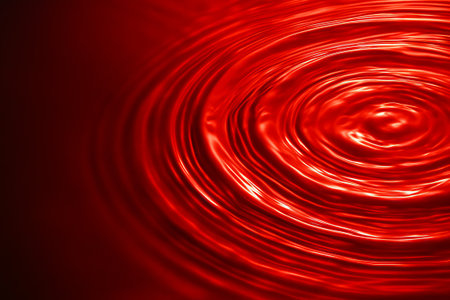 Close up of shiny red liquid with circular ripples spreading outwards. Abstract background with reflective wave pattern for art and design concept.の写真素材