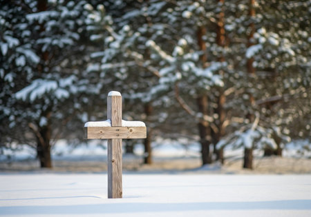 Wooden cross standing in deep snow with pine trees in background. Religious concept for Christmas, Easter, or memorial. Symbol of faith.の写真素材