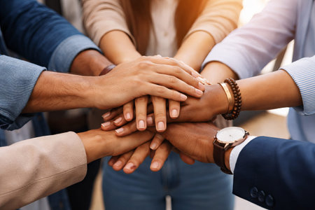 Men and women stacking hands together in unity. Diverse group showing teamwork. Collaborative effort...