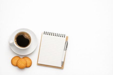 Coffee cup with cookies, blank notebook and pen on white desk. Simple breakfast or snack idea for relaxing break time, copy space.の写真素材