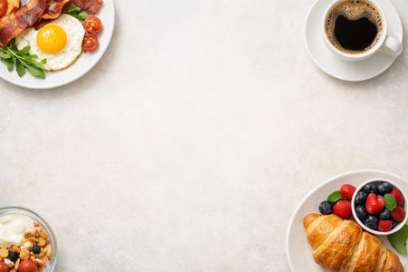 Hearty breakfast with croissant, berries, bacon and eggs on white table. Food background template...
