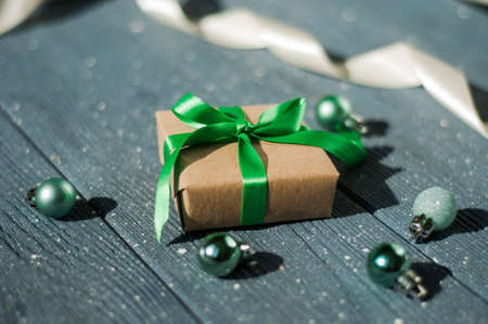Gift box with a ribbon bow. The concept of holidays and good mood. Balls for decorating the Christmas tree. Top view with copy space.の写真素材