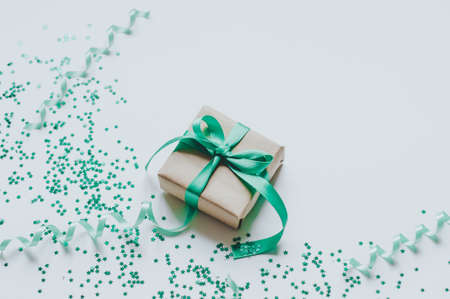 Gift box over star shaped golden sequins on a white background. Storage and order concept.の写真素材