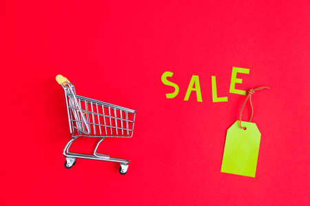 close-up of shopping trolley on color background with some copy space. Black Friday. Shopping Price tags sale on a red background. view from above.の写真素材