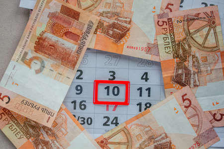Banknotes of dollars on calendar sheets closeup. Important dates on the calendar.の写真素材