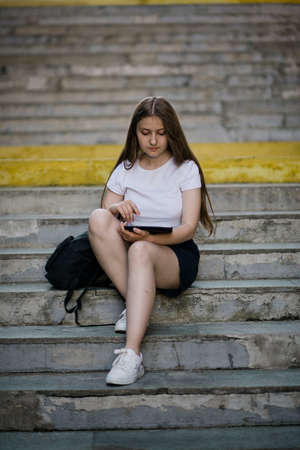 Learning female student preparing for graduation outdoors in summer.の写真素材
