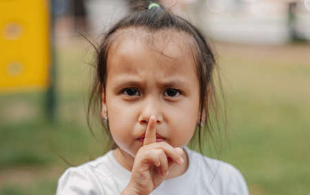 The child shows different emotions. A girl of 4-5 years old with dark hair. The child is very emotional, shows sadness and joy. Childrens education concept.の写真素材
