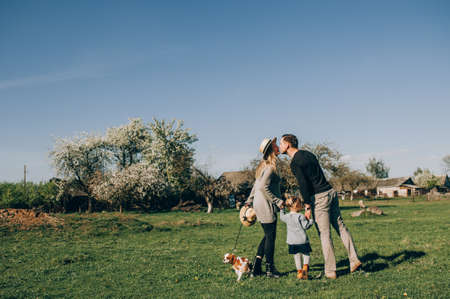 Family with dog walking in park.の写真素材