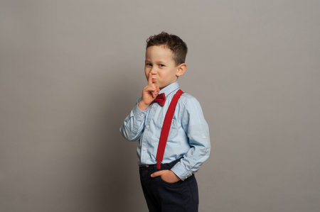 Happy boy laughs funny, screams in surprise, raising his hands up, the concept of childrens emotionsの写真素材