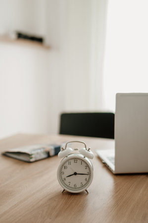 alarm clock on desktop, laptop and notebook for workの写真素材
