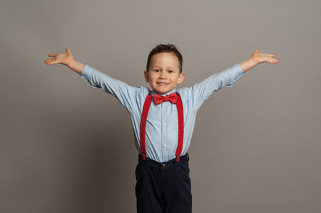 Happy boy laughs funny, screams in surprise, raising his hands up, the concept of childrens emotions.の写真素材