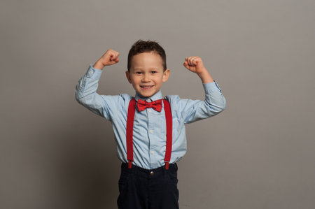 Happy boy laughs funny, screams in surprise, raising his hands up, the concept of childrens emotions.の写真素材