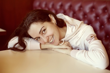 Portrait of young woman with brackets in cafeの写真素材