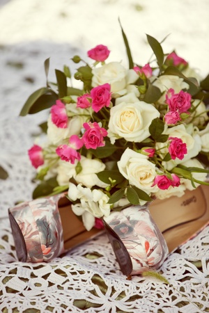 pink and white wedding bouquet of roses and bridal shoesの写真素材