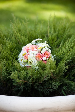 pink and white wedding bouquet in green grassの写真素材