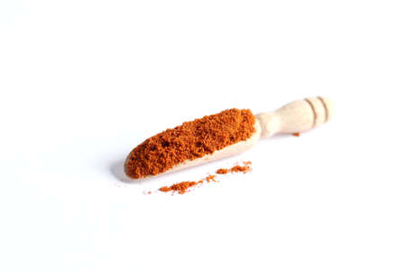 Paprika powder spices on spoons isolated on a white background