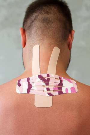 Kinesiology taping.Close up view of kinesiology tape on patient neck. Kinesiology, physical therapy, rehabilitation concept.の写真素材