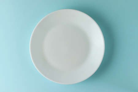 White empty plate on blue background.の写真素材