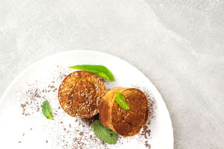 Apple and oatmeal cakes. Diet oat muffins with apples on a white plate on the gray background. Healthy food concept.の写真素材