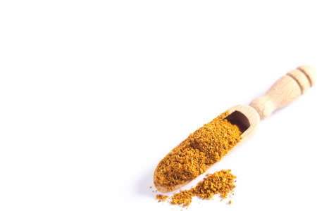 Curry powder in wooden scoop over white background. Top view.の写真素材