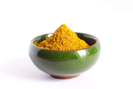 Turmeric powder in bowl isolated on white background. Indian spice.の写真素材