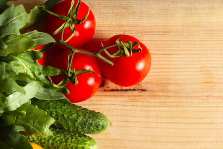 Overhead view of a delicious assortment of farm fresh vegetables and herbs spread out on a rustic wooden table.の写真素材