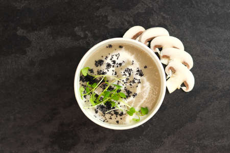 French cuisine hot food delivery - mushrooms soup closeup in eco paper bowl on black background. Delivery healthy eating concept.の写真素材