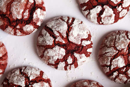 Red velvet crinkle cookies on a white baking paper. Chocolate chip cookies with cracks.