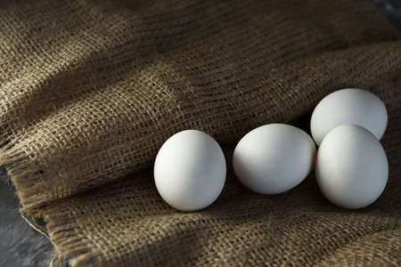 White chicken eggs on a burlap background. Selective focus.の写真素材