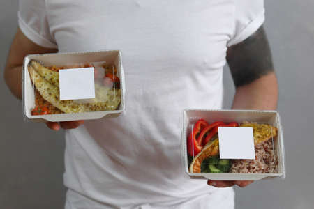 Delivery man hands giving food containers. Lunch boxes with food. Delivery healthy food concept