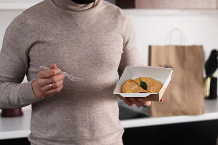 Woman with takeaway food in kitchen, closeup. Food delivery serviceの写真素材