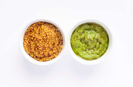 Sauce set - pesto and mustard seeds in gravy bowls isolated on white backgroundの写真素材