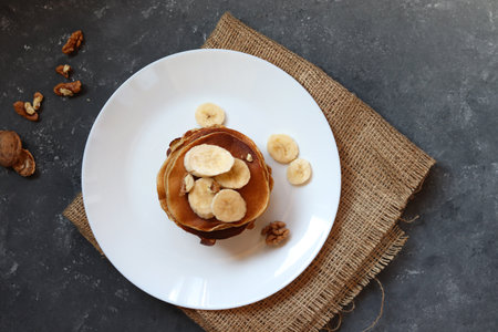 Protein pancakes with banana and walnut on a dark background.の写真素材