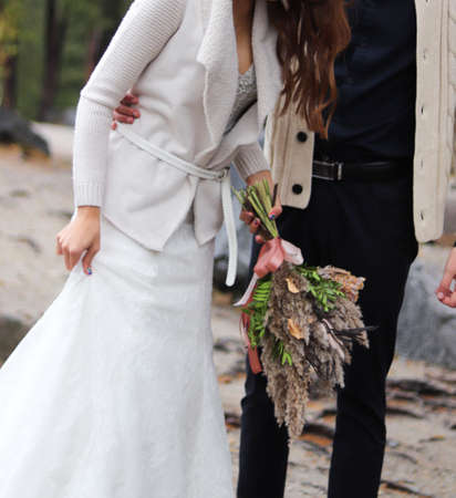 Wedding bouquet in the hands of the bride and groomの写真素材
