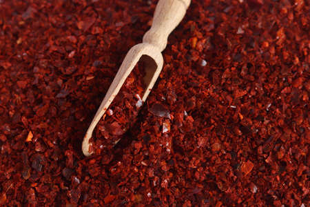 Heap of dried red chili flakes and wooden spoon as background. Spices and herbs. top view. Free...