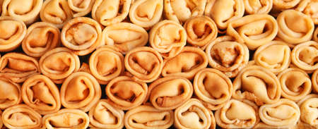 Stack of crepes rolls twisted with meat. Traditional Ukrainian russian thin pancakes as background. Tasty morning breakfast or lunch. Homemade food for maslenitsa. Banner.の写真素材