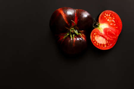 Fresh red tomatoes on a black background. Top view with copy space.の写真素材