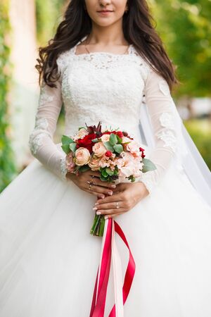 Bridal bouquet. Beautiful wedding dress. Close up. Vertical photo.の写真素材