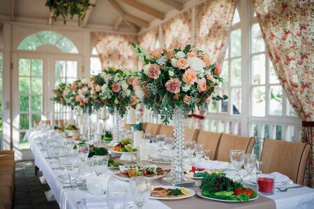 A very nicely decorated wedding table appointments with beautiful decor with plates and serviettes Beautiful flowers on table in wedding day.の写真素材