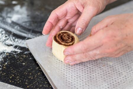 mother preparing a dough for cinnamon rolls at the kitchenの写真素材