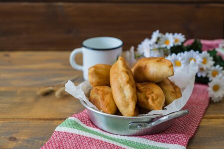 Pirojki. Traditional delicious Russian patty with potatoes on a wooden table , rustic style , with copy spaceの写真素材