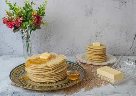 Moroccan pancakes Baghrir  Beghrir or crapes with 1000 holes served with honey and butter on grey...