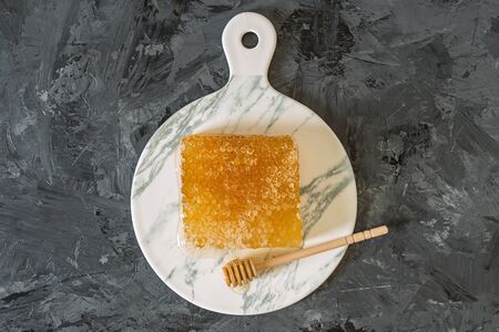 Honeycomb on marble plate on black background, top view, flat lay with copy spaceの写真素材